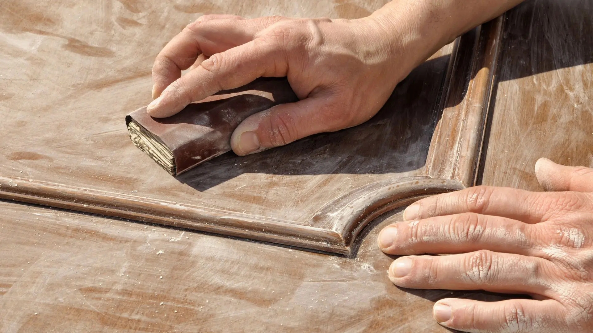 Craftsperson sanding wooden furniture