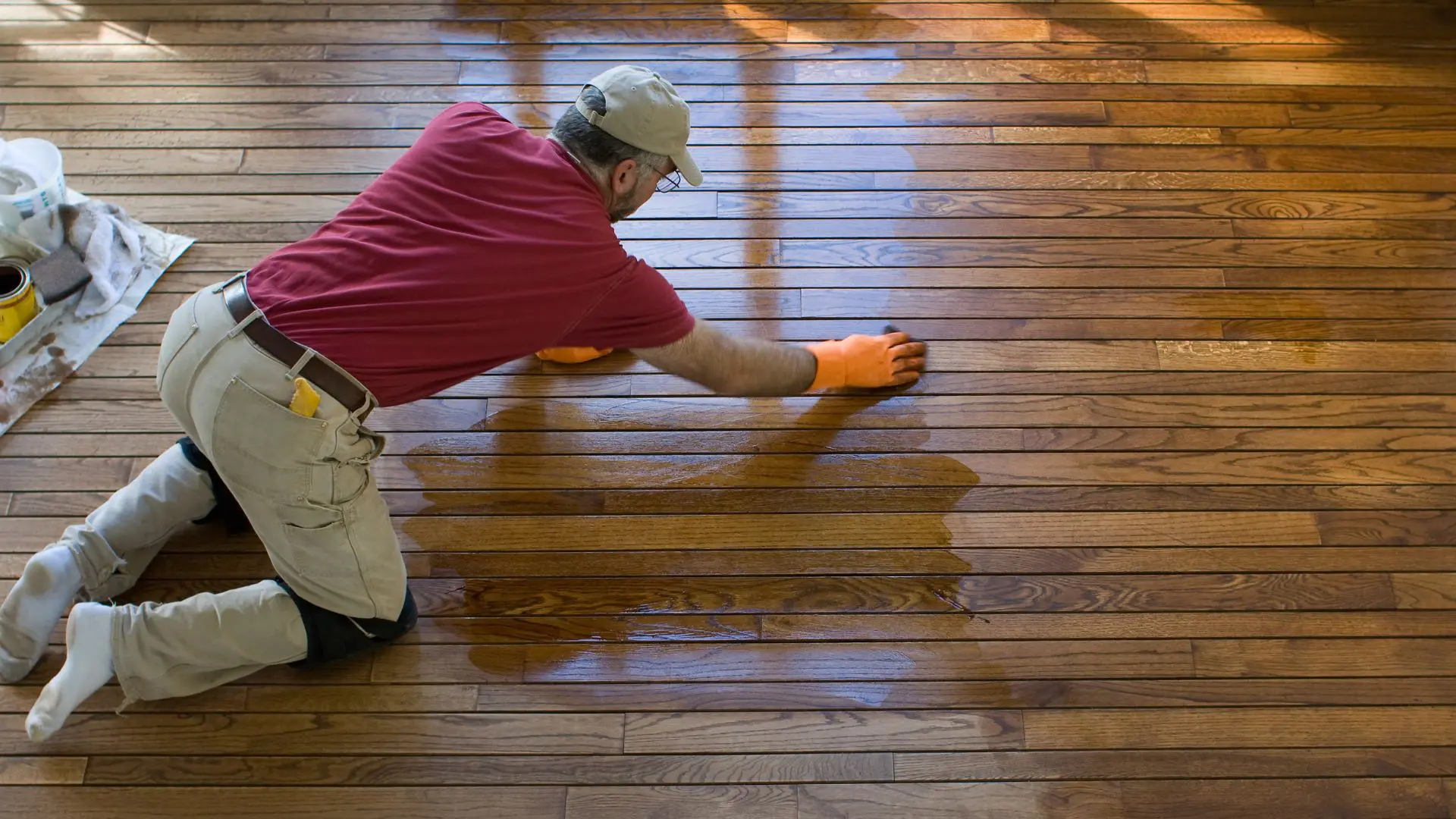 Man refinishing hardwood floor