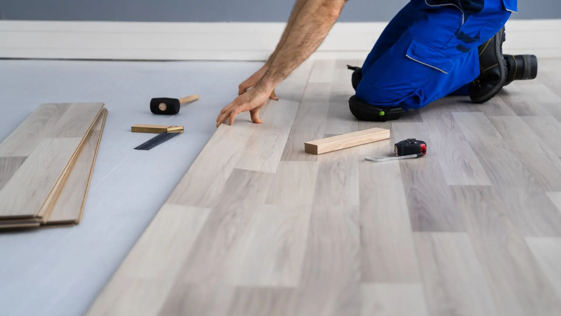 Person fitting wooden floor panels