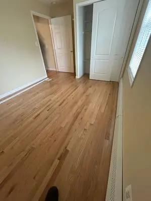 Sunlit room with hardwood flooring